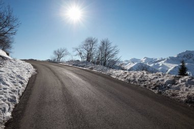 Boş dağ yolu ile kar taraf, mavi gökyüzü güneşli bir günde