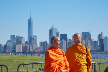 Güneşli bir günde New York şehir manzarası önünde iki Budist rahipler turuncu elbise