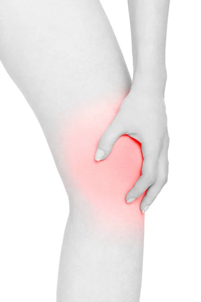 Mulher jovem segura a mão no joelho, área de dor vermelha isolada no fundo branco — Fotografia de Stock