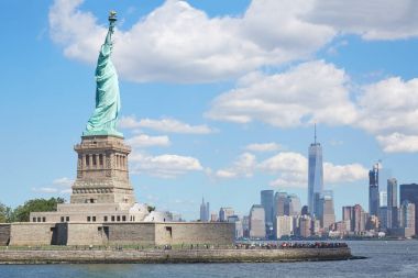 Liberty Adası'ndan ve New York şehir manzarası güneş ışığı altında heykeli