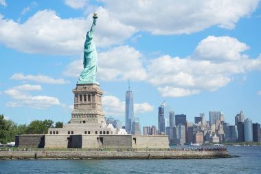Liberty Adası'ndan ve New York şehir silüeti güneşli bir günde heykeli