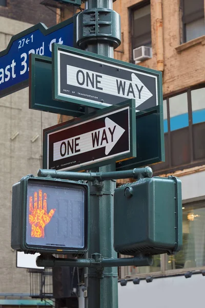 Ett sätt vägskylt påle i New York med rött trafikljus i staden — Stockfoto