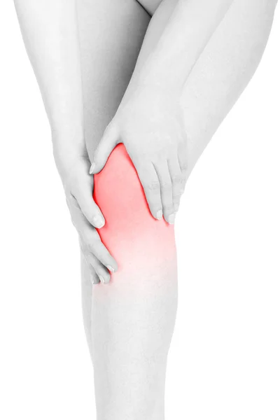 Молодая женщина трогает ногу, чувствуя боль в колене, красная область изолирована — стоковое фото