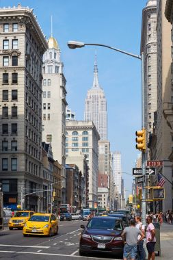 Empire State Binası ve Beşinci Cadde New York'ta güneşli bir günde insanlarla