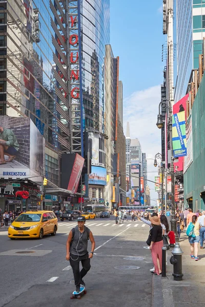 П'ята авеню з людини за допомогою Скейт ради та жовті таксі в Нью-Йорку — стокове фото