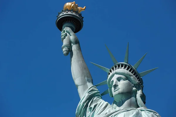 Freiheitsstatue mit goldener Fackel an einem sonnigen Tag, blauer Himmel in New York — Stockfoto