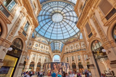 Galleria Vittorio Emanuele interior with people, sunlight in Milan, Italy clipart