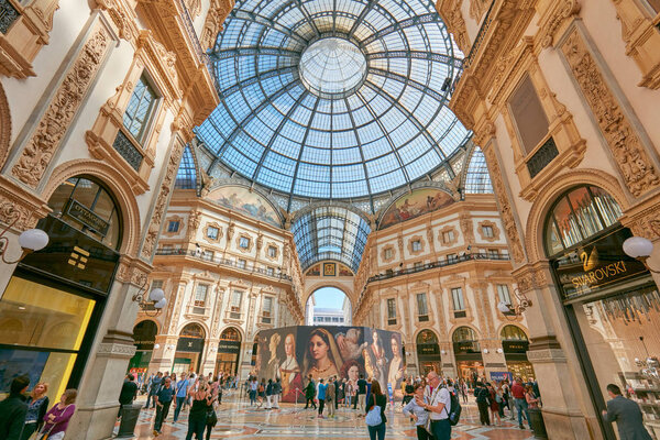 Galleria Vittorio Emanuele interior with tourists and luxury shops in Milan, Italy