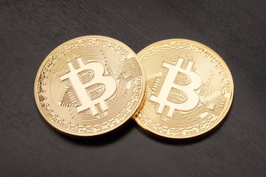 Siyah arka plan üzerine iki altın Bitcoin 