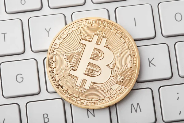 Ein goldener Bitcoin auf weißer Tastatur, Clipping-Pfad — Stockfoto
