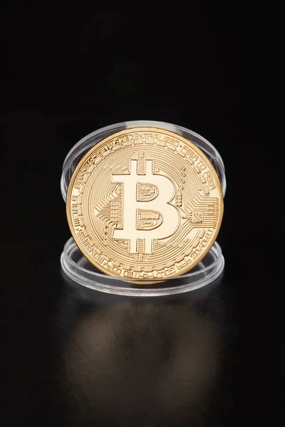 Goldener Bitcoin im transparenten Münzbehälter auf schwarz — Stockfoto