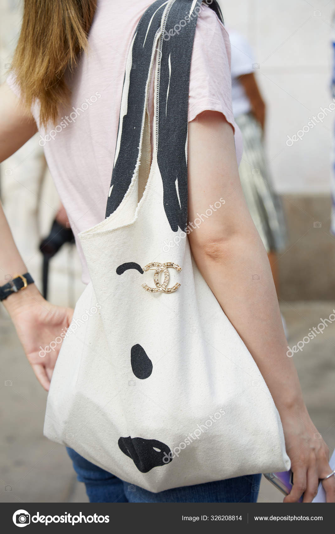 Woman with black and white tote bag with Chanel brooch before