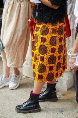 Tiziano Guardini moda defilesinden önce sarı etekli ve siyah Dr Martens çizmeli kadın, Milan Moda Haftası tarzı. 
