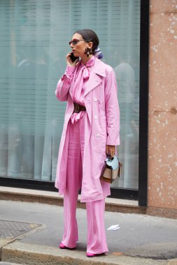 Calcaterra moda defilesinden önce pembe paltolu ve pantolonlu kadın, Milan Moda Haftası tarzı. 