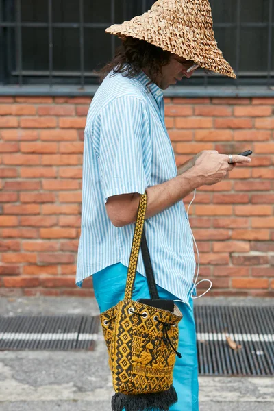 Man med korgkeps, blå byxor tittar på smartphone innan Arthur Arbesser modevisning, Milan Fashion Week street style — Stockfoto