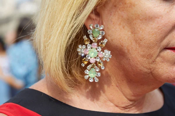 Femme avec boucle d'oreille croisée avec gemmes vertes et roses avant le défilé de mode Tiziano Guardini, Milan Fashion Week street style — Photo