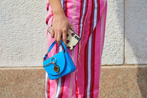 Mujer con bolso de cuero azul JW Anderson y pantalones a rayas rosas antes del desfile de moda Tiziano Guardini, Milan Fashion Week street style — Foto de Stock