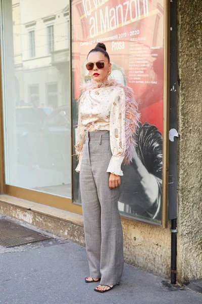 Woman with shirt with pink feathers and gray trousers before Peter Pilotto fashion show, Milan Fashion Week street style — Stock Photo, Image