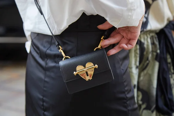 Mujer con bolso Prada de cuero negro con corazón dorado antes del desfile de moda Peter Pilotto, Milan Fashion Week street style — Foto de Stock