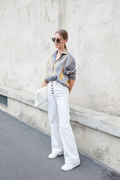 Mujer con camisa de seda gris y dorada y pantalones blancos antes del desfile de moda Prada, Milan Fashion Week street style — Foto de Stock