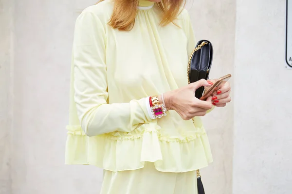 Mulher com Miu Miu relógio dourado e camisa amarela olhando para o smartphone antes do desfile de moda Prada, estilo de rua Milan Fashion Week — Fotografia de Stock