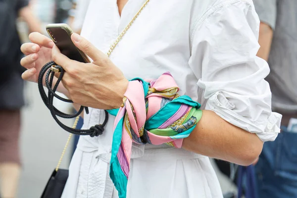 Kvinna med vit klänning och halsband som håller smartphone innan Prada modevisning, Milan Fashion Week street style — Stockfoto