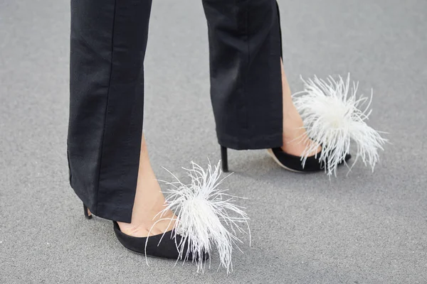 Mujer con zapatos de tacón alto negro con plumas blancas antes del desfile de moda Prada, Milan Fashion Week street style —  Fotos de Stock