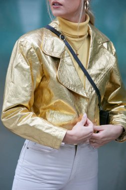 Altın deri ceketli ve sarı balıkçı yakalı kadın Emporio Armani moda defilesinden önce, Milan Moda Haftası tarzı 