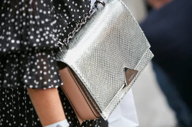 Emporio Armani marka, gümüş renkli, deri çantalı, siyah beyaz puantiyeli kadın. Emporio Armani moda defilesinden önce, Milan Moda Haftası tarzı. 