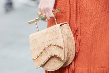 Emporio Armani defilesinden önce mantar çantalı ve turuncu elbiseli kadın, Milan Moda Haftası tarzı. 