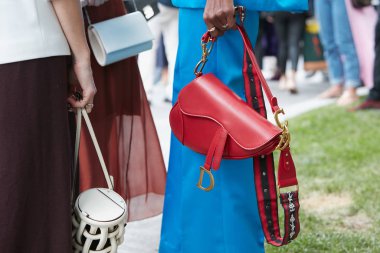 Kırmızı deri çantalı ve mavi pantolonlu kadın Emporio Armani moda defilesinden önce, Milan Moda Haftası 