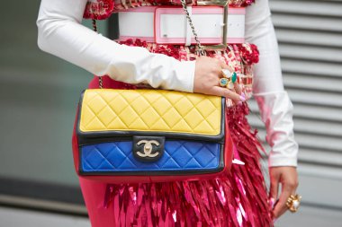Sarı, mavi ve kırmızı Chanel çantalı ve pembe etekli kadın Emporio Armani defilesinden önce, Milan Moda Haftası tarzı 