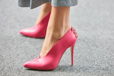 Emporio Armani defilesinden önce yüksek topuklu pembe deri ayakkabılı bir kadın, Milan Moda Haftası tarzı. 