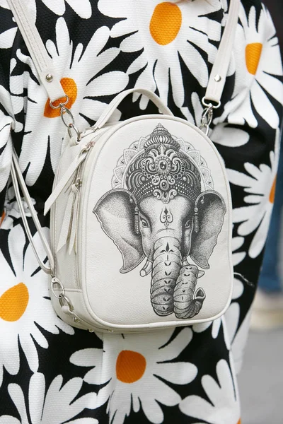 Vrouw met witte rugzak met olifant design en jas met madeliefjes voor Emporio Armani modeshow, Milaan Fashion Week street style — Stockfoto