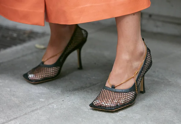 Mujer con zapatos de tacón alto de red negra y cadena dorada antes del desfile de moda Emporio Armani, Milan Fashion Week street style — Foto de Stock