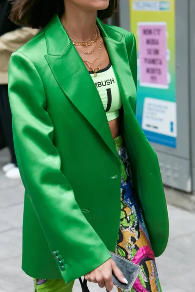Nő zöld szatén kabát és színes nadrág arany nyaklánccal előtt Emporio Armani divatbemutató, Milánó Fashion Week street style — Stock Fotó