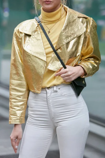 Mujer con chaqueta de cuero dorado y pantalones Armani blancos antes del desfile de moda Emporio Armani, Milan Fashion Week street style —  Fotos de Stock