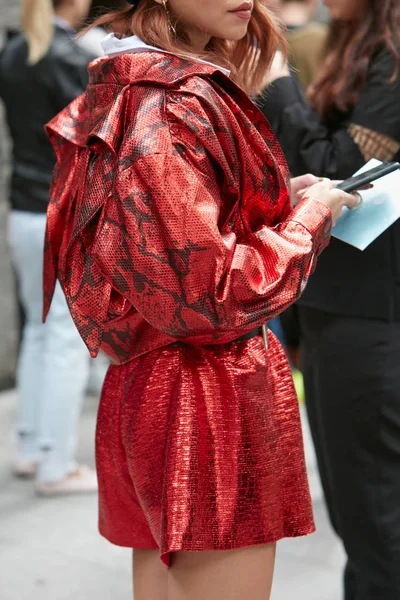 Donna con giacca di pelle rossa di rettile e pantaloncini metallici prima della sfilata di Emporio Armani, Milano Fashion Week street style — Foto Stock