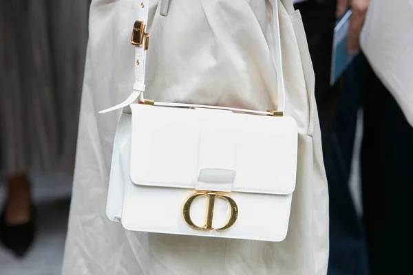Женщина с белой кожаной сумкой Christian Dior с золотым логотипом перед показом мод Emporio Armani, стиль улицы Milan Fashion Week — стоковое фото
