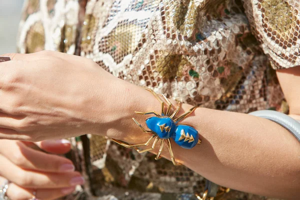 Femme avec bracelet araignée bleu et or avant le défilé Genny, Milan Fashion Week street style — Photo