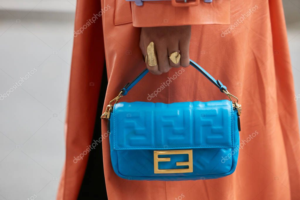 MILAN, ITALY - SEPTEMBER 19, 2019: Woman with pink coat and bag with golden chains before Fendi fashion show, Milan Fashion Week street style