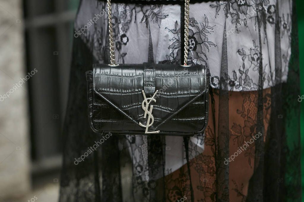 MILAN, ITALY - SEPTEMBER 19, 2019: Woman with pink coat and bag with golden chains before Fendi fashion show, Milan Fashion Week street style