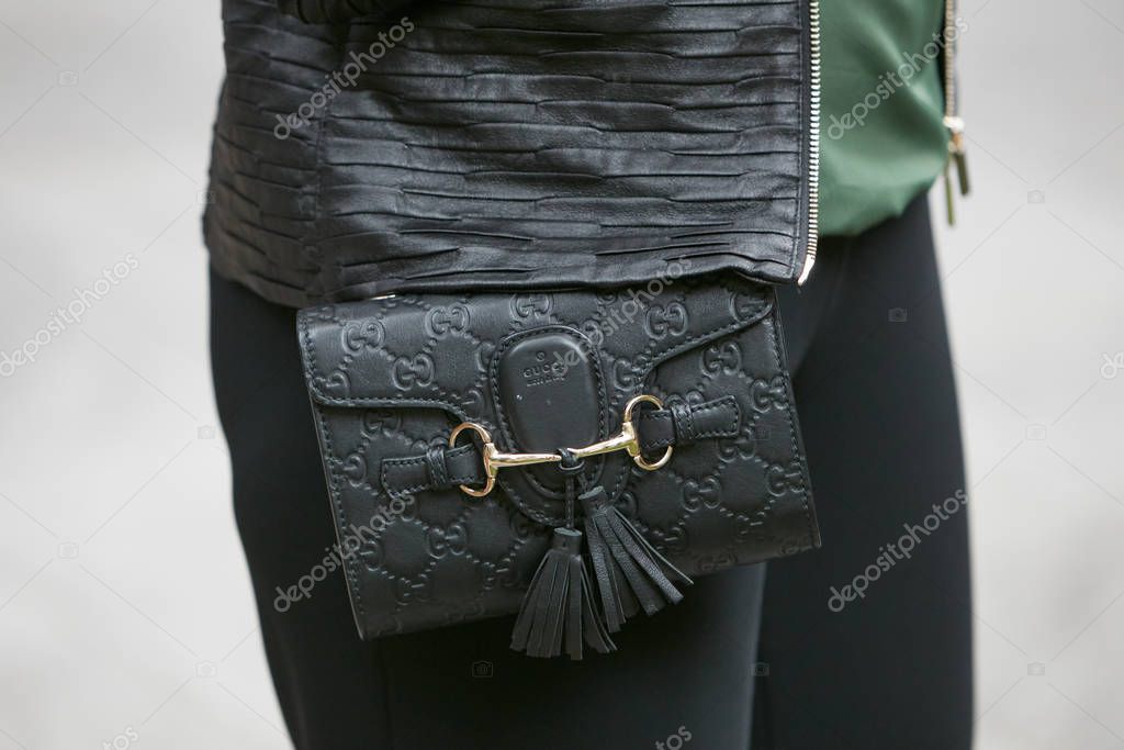 MILAN, ITALY - SEPTEMBER 19, 2019: Woman with pink coat and bag with golden chains before Fendi fashion show, Milan Fashion Week street style