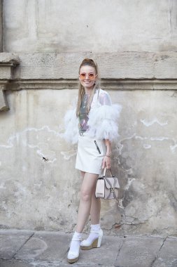 Bottega Veneta moda defilesinden önce beyaz etekli ve pembe metalik gömlekli kadın, Milan Moda Haftası tarzı. 