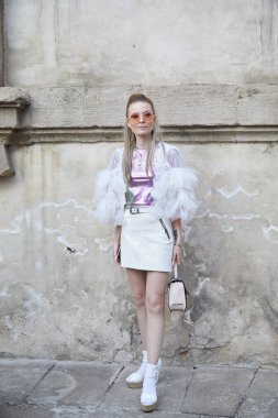 Bottega Veneta moda defilesinden önce beyaz etekli ve pembe metalik gömlekli kadın, Milan Moda Haftası tarzı. 
