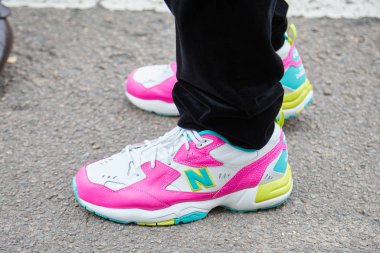 Fendi defilesinden önce beyaz, pembe ve mavi spor ayakkabılı bir adam, Milan Moda Haftası tarzı. 