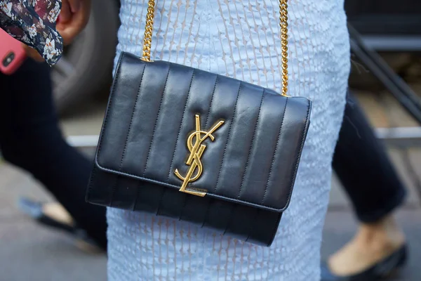 Wanita dengan kulit hitam Yves Saint Laurent tas dengan logo emas dan gaun biru sebelum Luisa Beccaria fashion show, Milan Fashion Week gaya jalan — Stok Foto