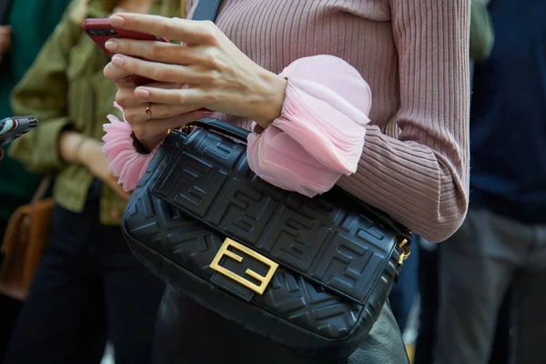 Женщина с черной кожаной сумкой Fendi с золотым логотипом и розовыми наручниками перед показом мод Bottega Veneta, стиль улицы Milan Fashion Week — стоковое фото