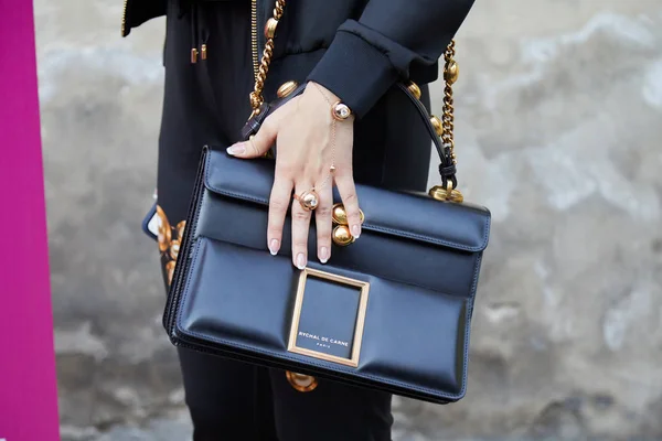 Mujer con bolso Rychal De Carne de cuero negro y joyas doradas antes del desfile de moda Bottega Veneta, Milan Fashion Week street style — Foto de Stock