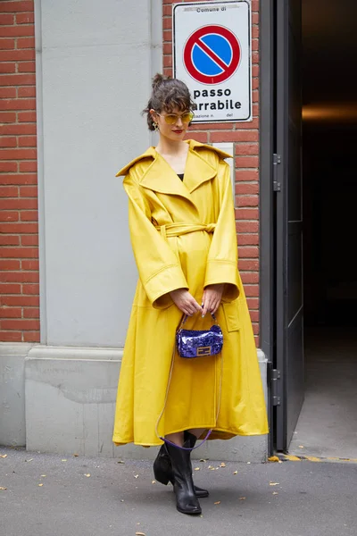 Mujer con gabardina de cuero amarillo y bolso Fendi azul antes del desfile de moda Fendi, Milan Fashion Week street style —  Fotos de Stock